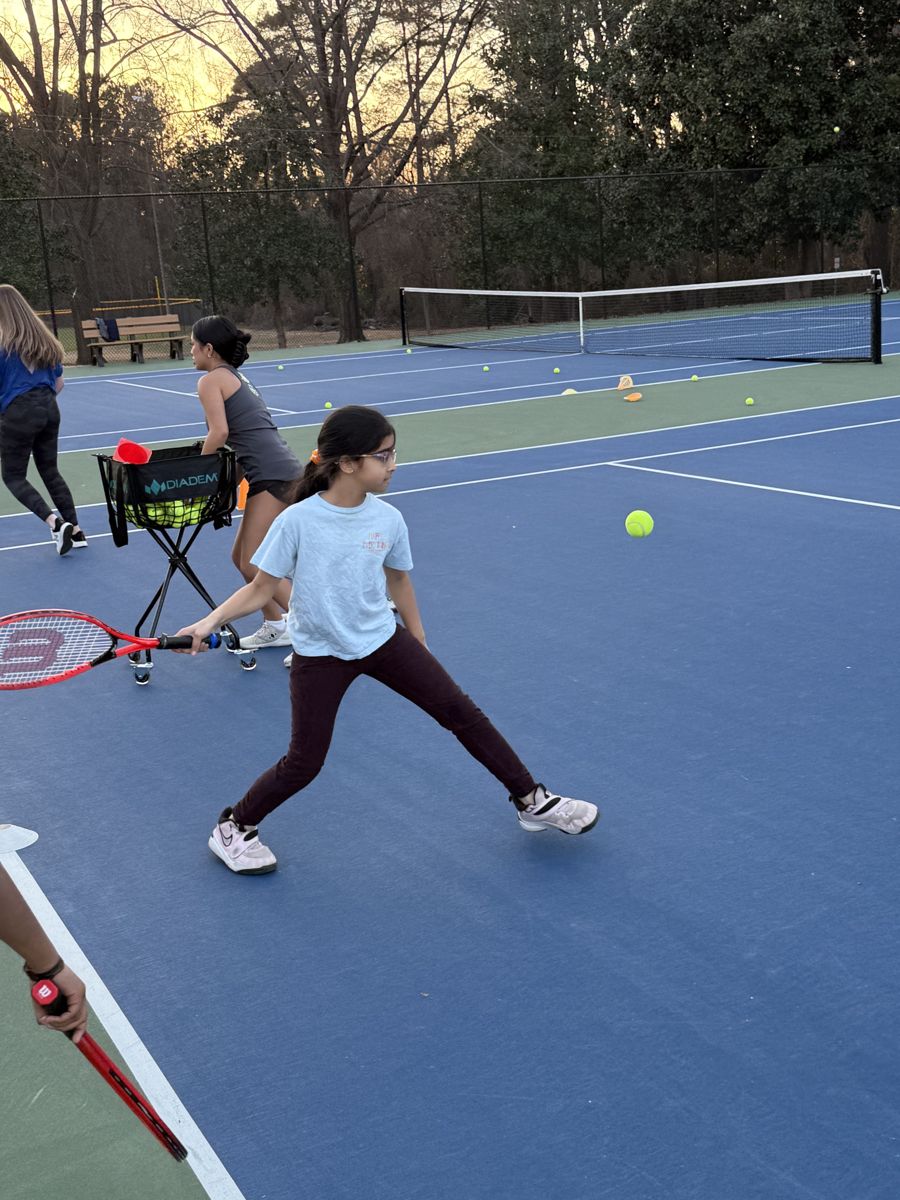 Young Big NC player tracking a forehand on a blue court