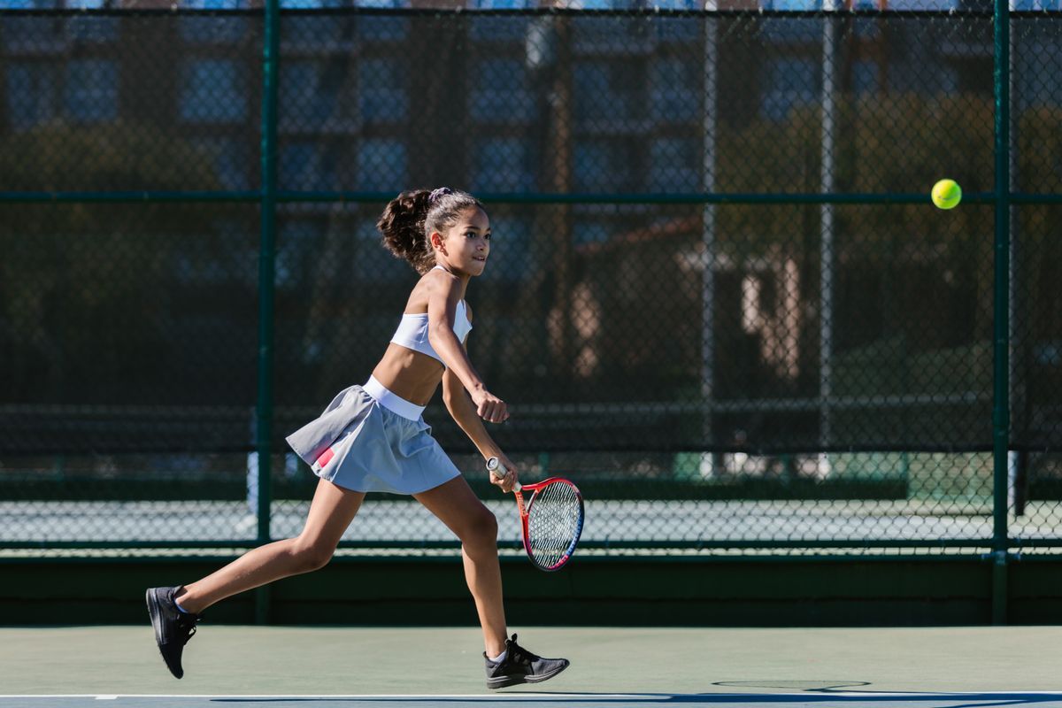 Teen player running to hit a forehand