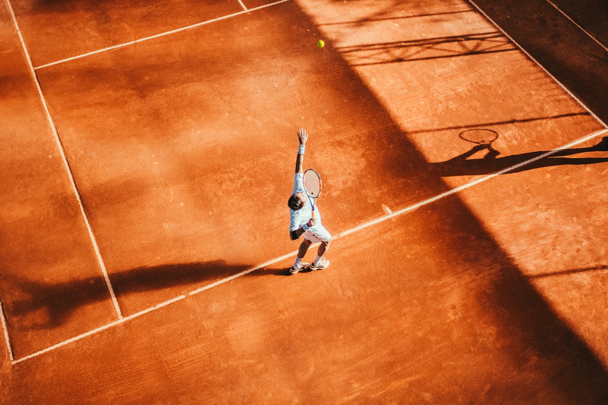 Overhead serve on clay with racket and ball