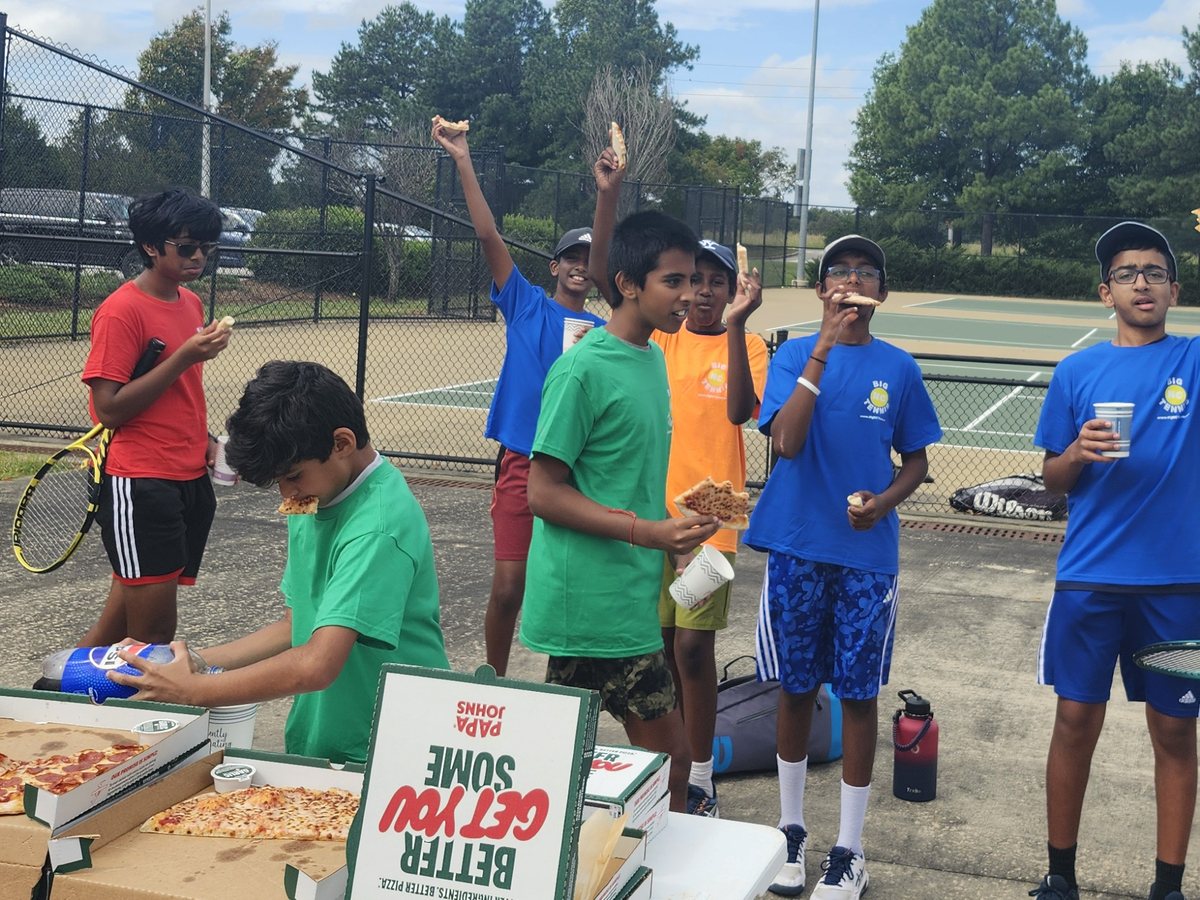 Big NC junior players sharing pizza courtside